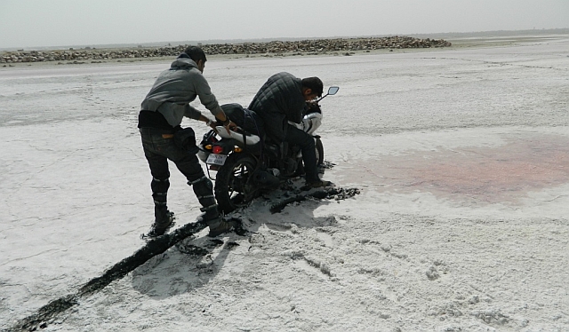 motorcycle stuck in the salt mud, being pulled out