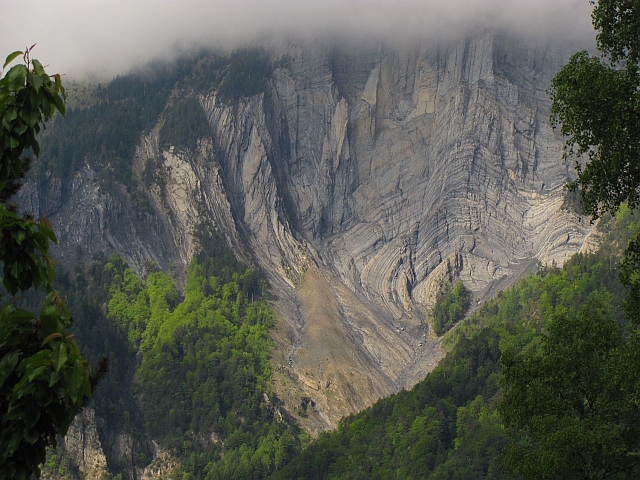 radical swirls and deformations in the rock strata and layers on a mountain side in the french alps