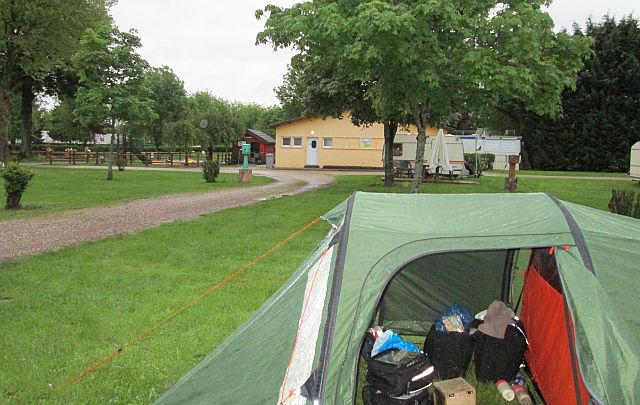 my tent on the grass at the campsite in auxonne with the toilet block behind