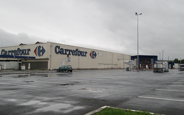 large empty car park in front of a closed empty carrefour supermarket in epernay
