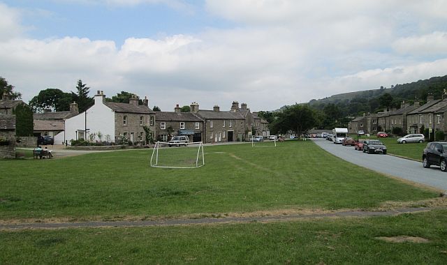 another view of the billage green west burton, grass and stone buildings and houses