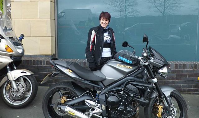 jr stands proudly behind her lowered street triple r