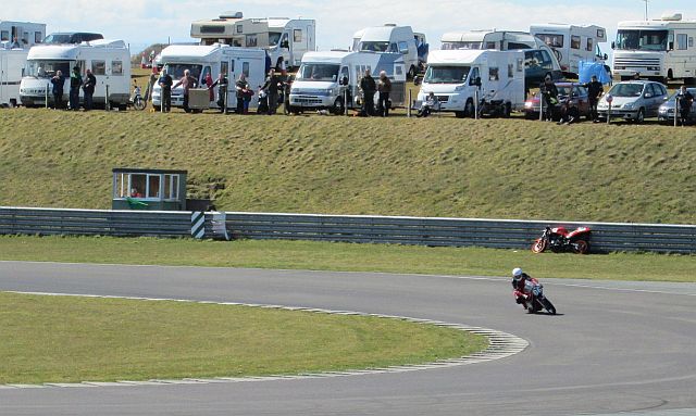a classic motorcycle racing around a track at anglesey