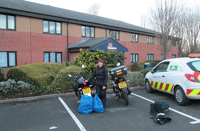 outside the plain travelodge the gf stands with bags and our motorcycles