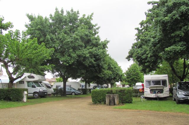 campervans line the gravel track through the rain soaked campsite