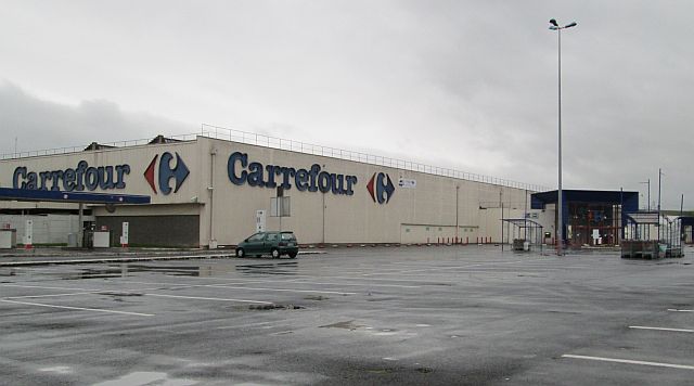 a dull off white slab of a building, carrefour supermarket in france