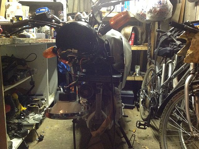 the 250 minus the forks and other bent items, looking forlorn in a garage