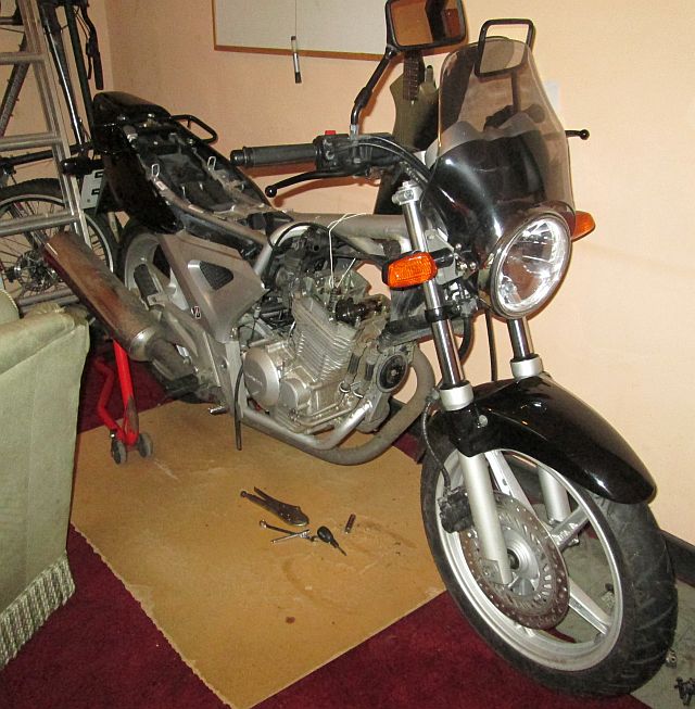 black cbf 250 with the rocker cover off in a living room