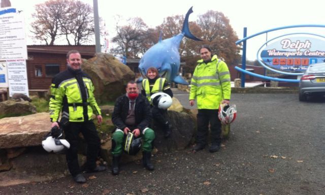 4 motorcyclists in wet weather gear sat on stones at eccleston delph diving centre