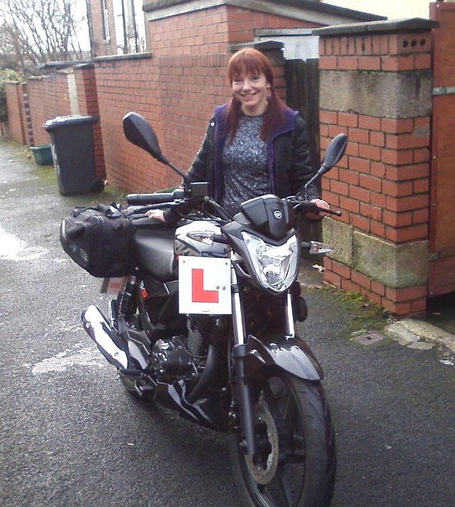 the gf standing next to her keeway rks 125 in the back street