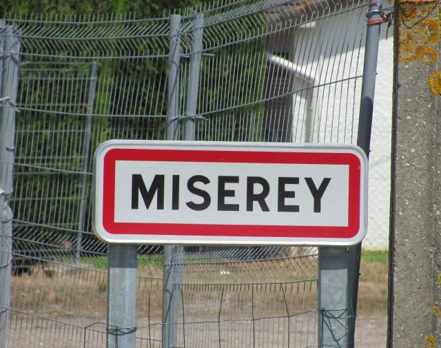 the town sign for miserey france, black writing on white background with red border