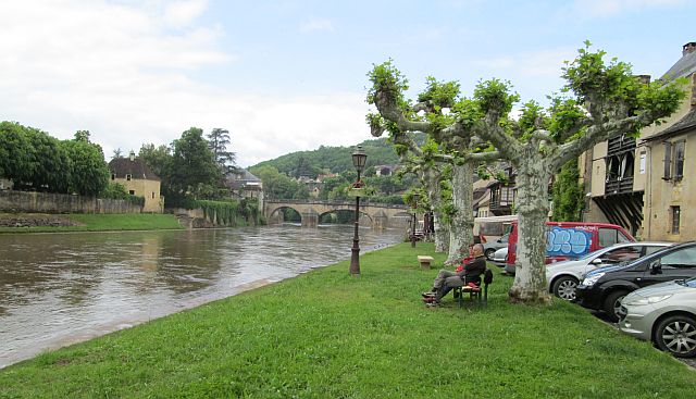 the swollen and mud red river flowing through pretty montignac