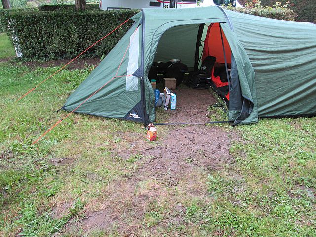 the tent and a muddy path from within the porch to the gravel track