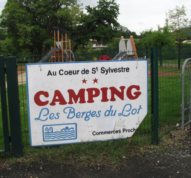 a scruffy sign for camping les berges du lot