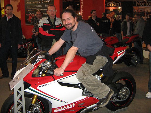 Ren sat on a ducati on a stand at a motorcycle show