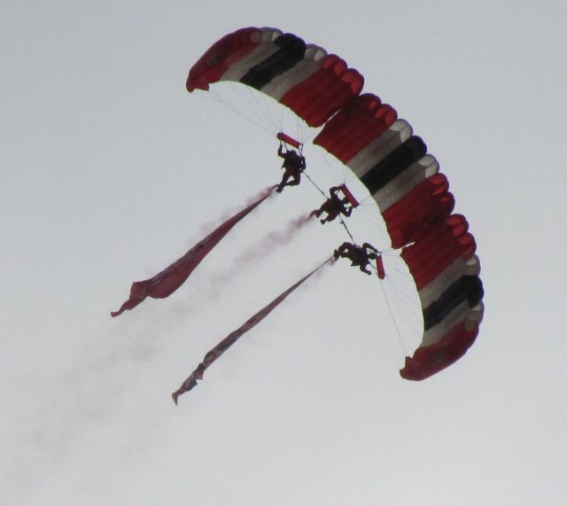 three red devils skydivers in tight formation