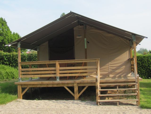 a large, permanent safari style tent with a wooden veranda
