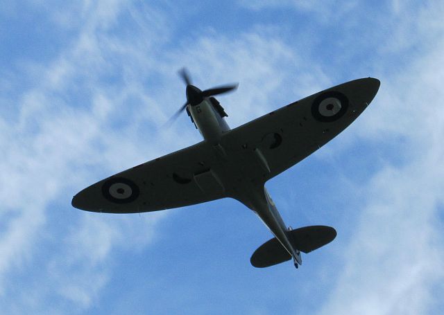 the underneath of a spitfire flying overhead at the ride to the wall