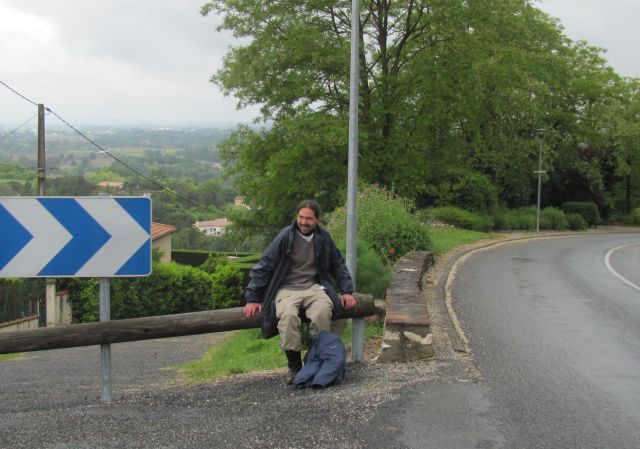 the bf as he catches his breath sat on a barrier at the top of the steep road