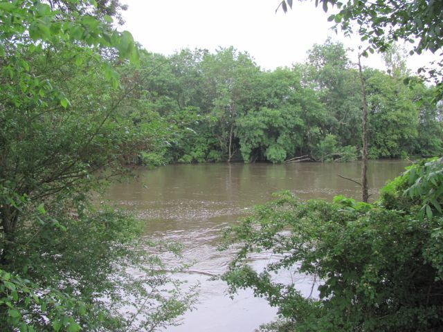 a full and swollen river flowing through trees at barrou