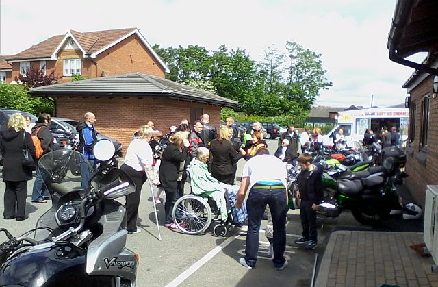 a group of bikers outside woodlands hospice in the hazy sunshine