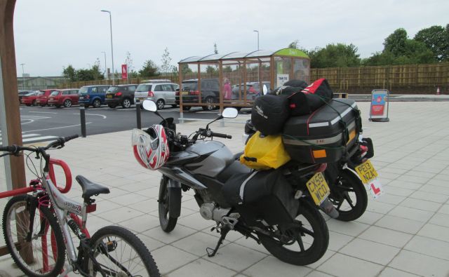 ren and sharon's 125cc motorcycles parked outside lincoln tesco, loaded up with camping gear