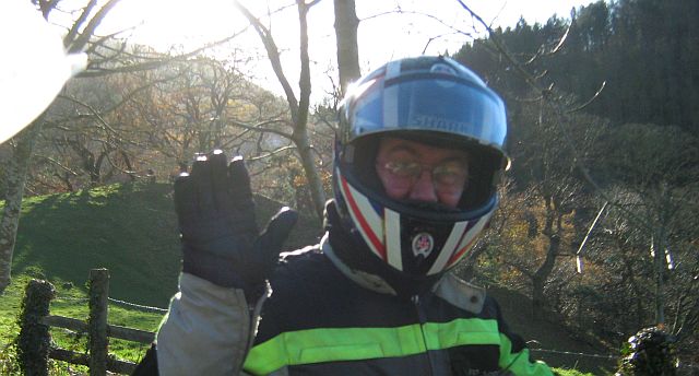 a biker waving to the camera quite close up