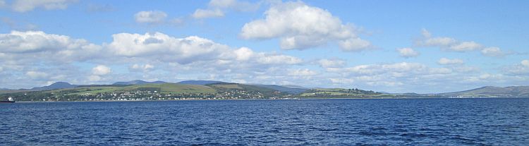 a wide view of the firth of clyde. blue waters with hills and mountains in the distance 