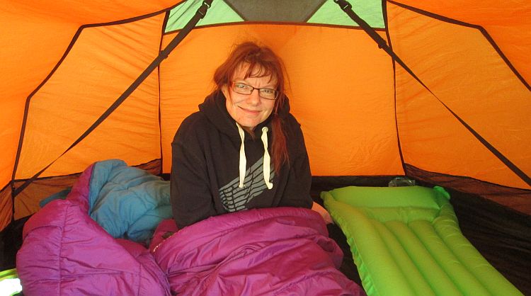 the gf smiles from her sleeping bag in the tent at the campsite