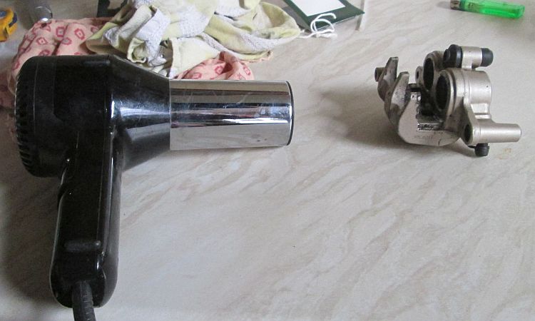 using a hairdryer to remove any water from the clean calliper
