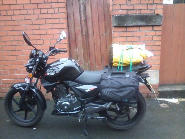 Keeway TKS 125 motorcycle with saddle bags and a roll on the back seat