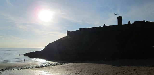 peel castle outlined by the low sun