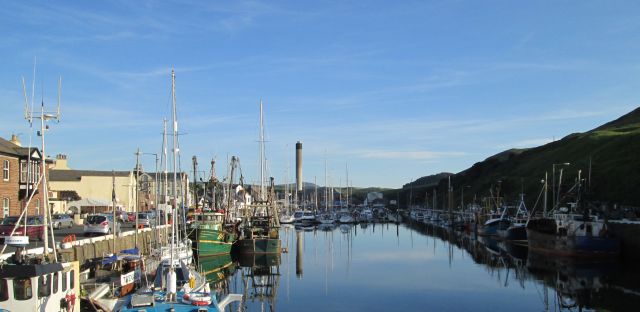 peel harbour filled with trawlers and yachts and clear blue skies