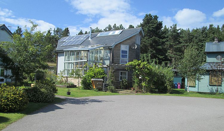a large oddly shaped house with solar panel and all kind of material at findhorn