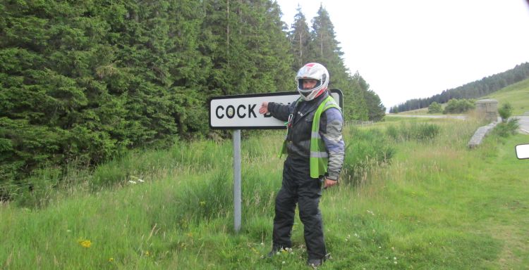 ren stands by the cock bridge sign, covering the word bridge with his arm