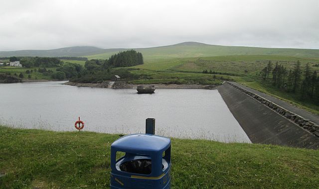 sulby reservoir, a man made reservoir set in woods, hills and a misty backdrop