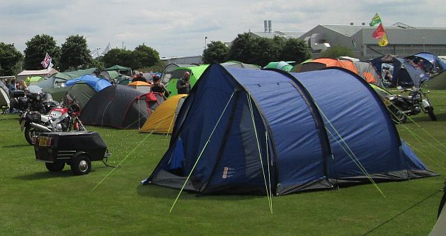 a large blue tent and a small trailer at a motorycle rally
