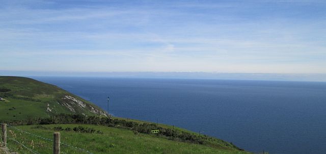 blue skies, deep blue sea and verdant green hills in the isle of man