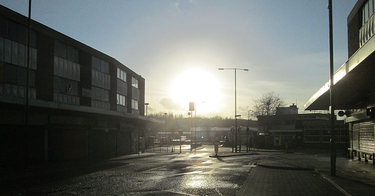 a low bright sun set over the concrete buildings in radcliffe