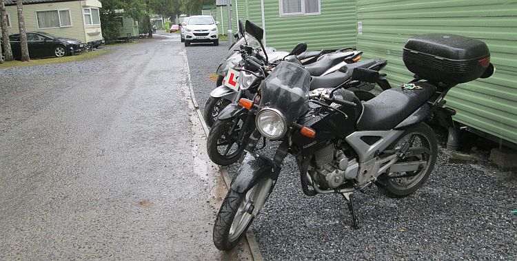 4 wet motorcycles in a line next to a static caravan at tummel valley holiday park