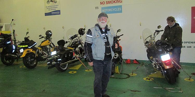 A CMA member stands in the bowels of the ship next to the motorcycles strapped down