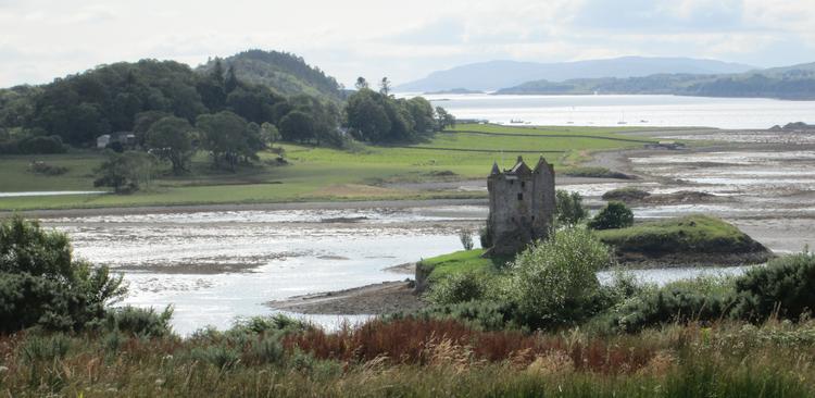 Castle Stalker, a ruin set against a beautiful loch and hills