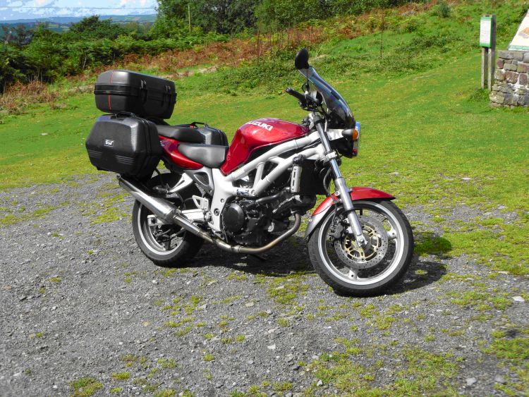 Suzuki's SV 650 in a deep red. Complete with hard luggage and screen