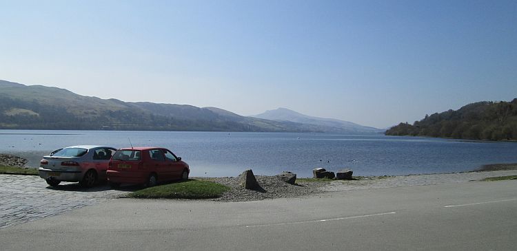Lake Bala glistening in a hazy sun with the mountains behind