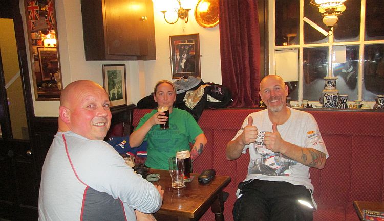 3 riders drinking, smiling and giving the thumbs up at the pub in Kirky stephen