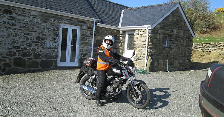 Sharon sits on her bike smiling and ready to ride the welsh roads