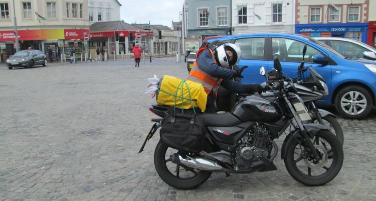 Sharon makes a silly pose next to her 125 in Caernarfon