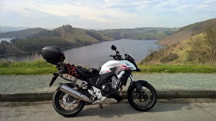 Honda's CB500X in white against another magnificent backdrop of hills and lakes