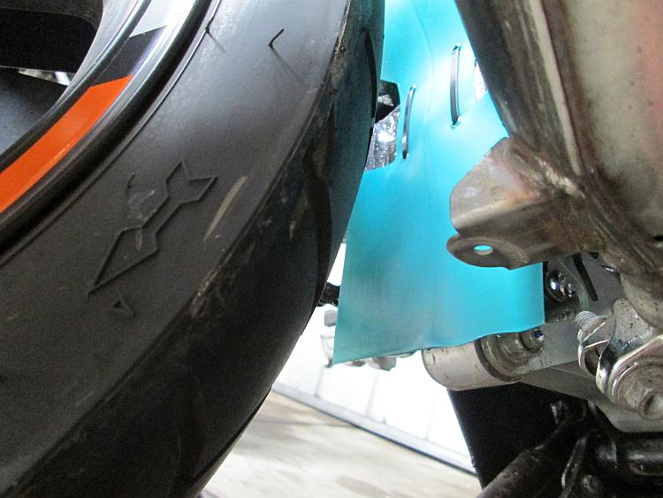 A piece of plastic zip tied to the swing arm protects the costly bearing on Ren's 500