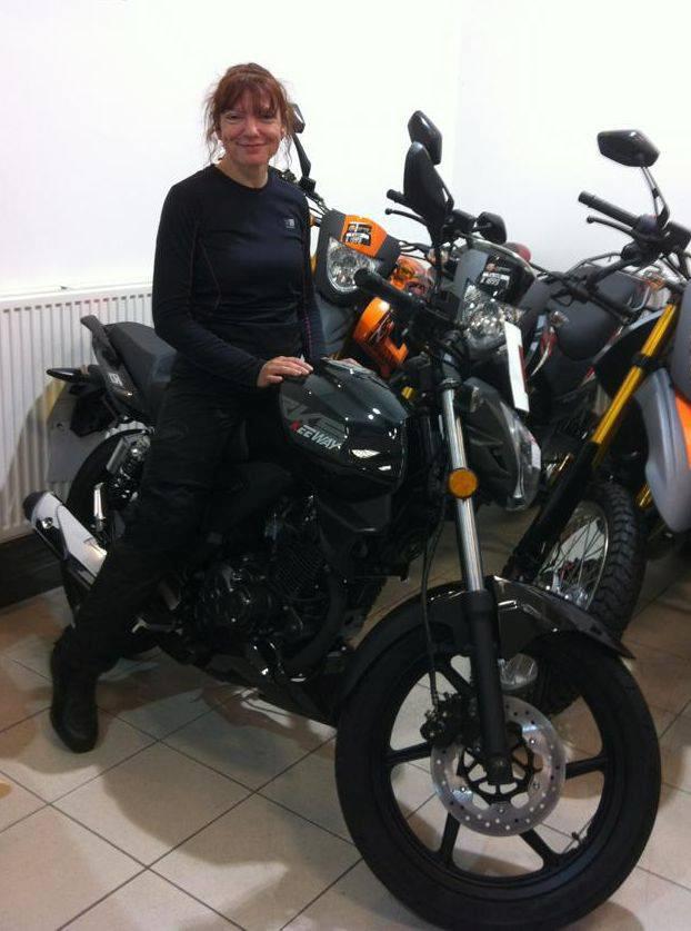 Sharon sits astride the 125 before she's even purchased it to start riding
